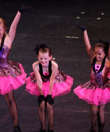 Enfants dansant en danse moderne sur scène, costumes roses