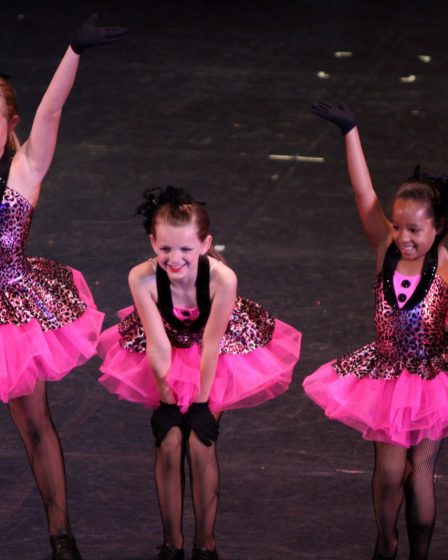 Enfants dansant en danse moderne sur scène, costumes roses