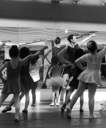 Professeure et jeunes danseuses en cours, photo artistique noir et blanc