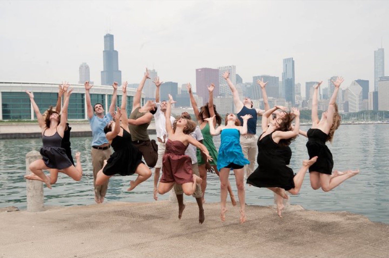 Groupe de danseurs sautant joyeusement en extérieur, bras levés