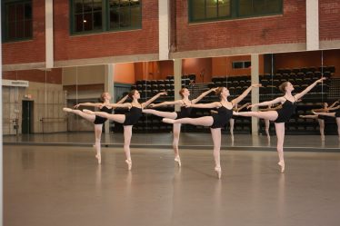 Jeunes danseuses en cours de danse, arabesque à la barre face au miroir