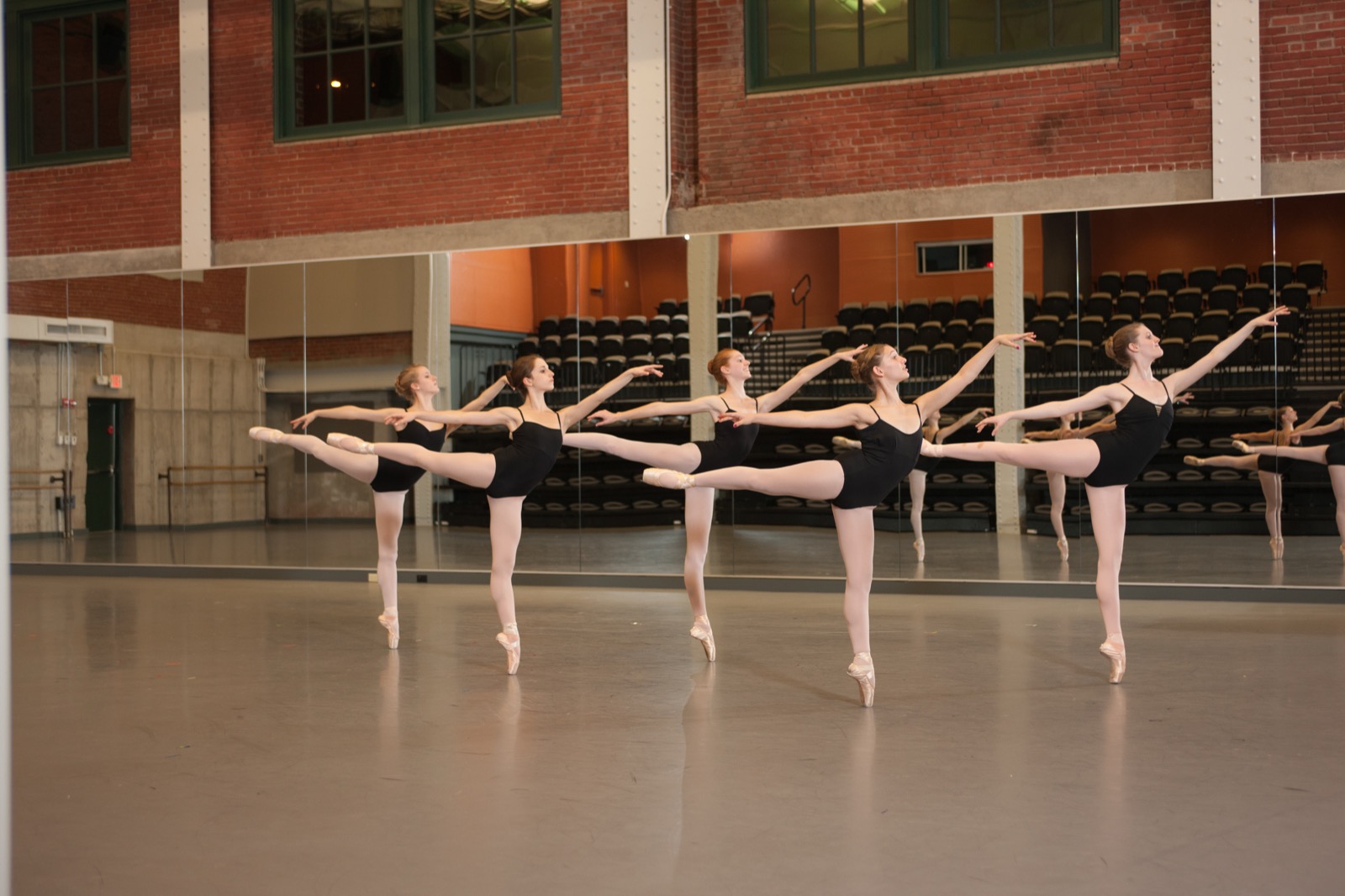 Jeunes danseuses en cours de danse, arabesque à la barre face au miroir