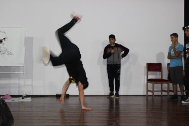 Danseur de breakdance en figure acrobatique sur scène