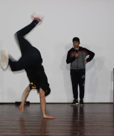 Danseur de breakdance en figure acrobatique sur scène