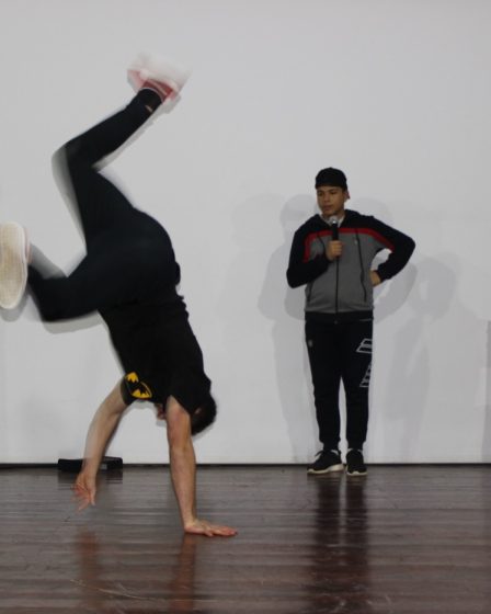 Danseur de breakdance en figure acrobatique sur scène